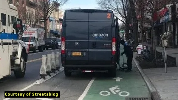 image of car parked inside delineators on grand street bike lane